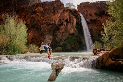 男子跳水在水附近的瀑布
